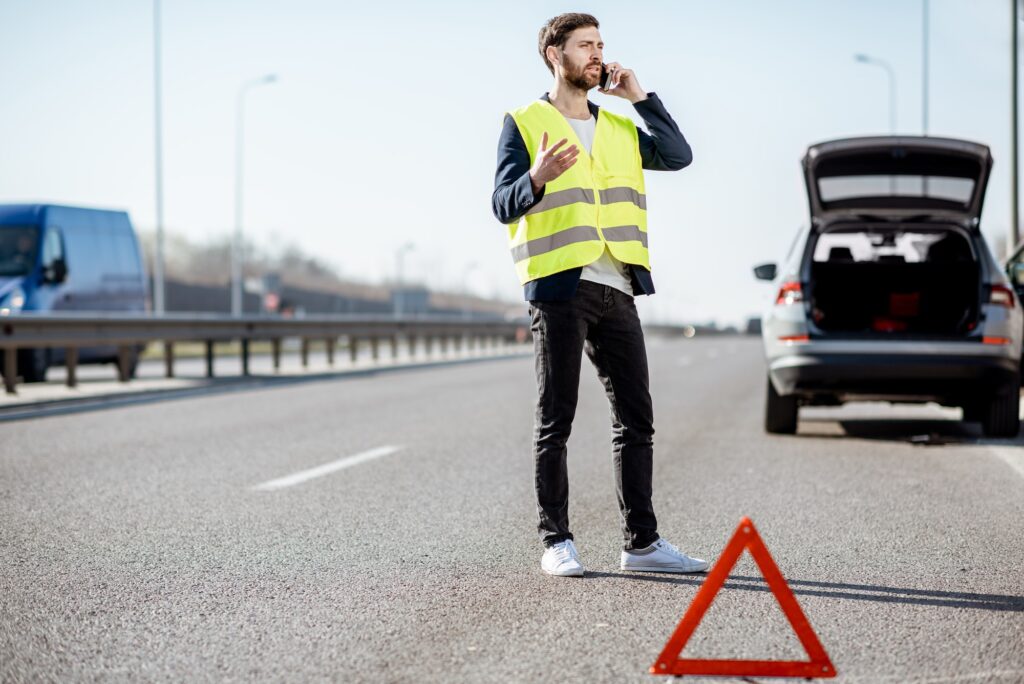 Man calling road assistance on the highway